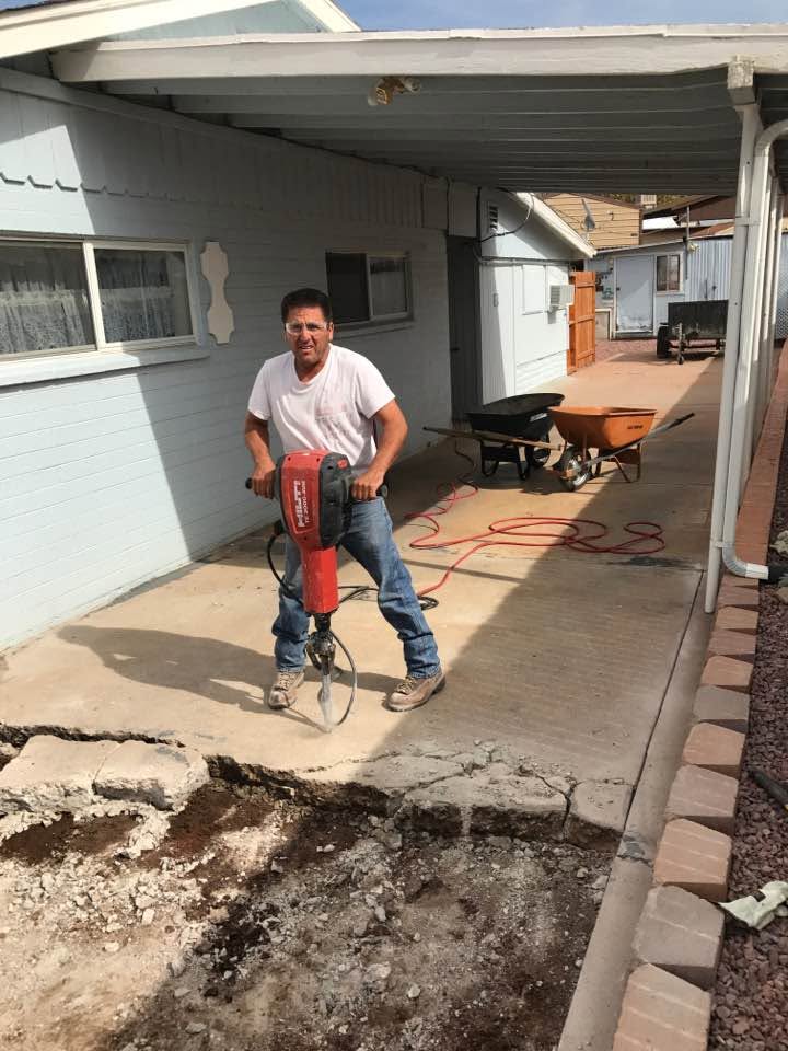 Lupe Lopez operating a jackhammer during concrete demolition on a residential property